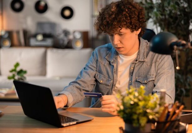 A,Young,Man,With,Curly,Hair,Sitting,In,Front,Of