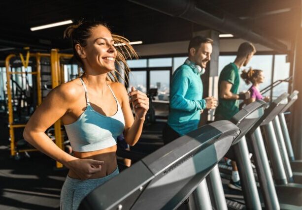 Happy,Athletic,People,Jogging,On,Treadmills,In,A,Health,Club.