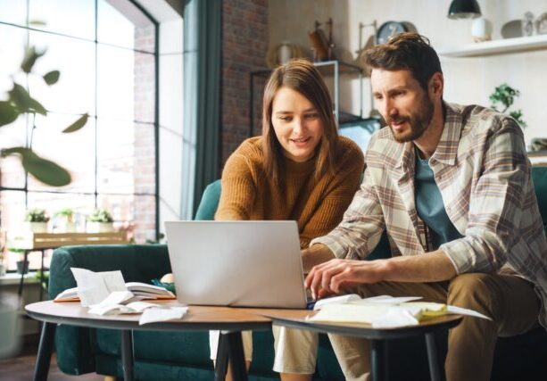 Doing,Accounting,At,Home:,Happy,Couple,Using,Laptop,Computer,,Sitting