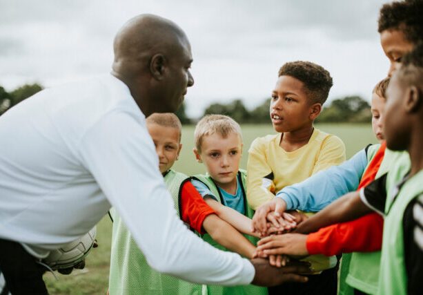 Junior,Football,Team,Stacking,Hands,Before,A,Match