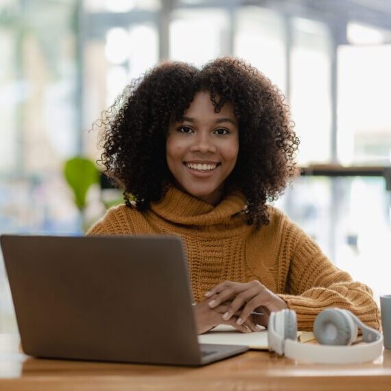 African,American,Girl,Writing,In,Notebook,Sitting,At,Desk,With