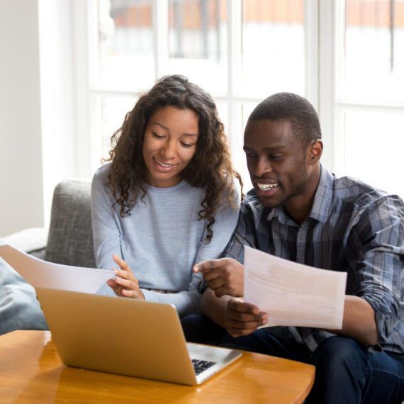 African,Black,Positive,Married,Couple,Sitting,On,Sofa,At,Home